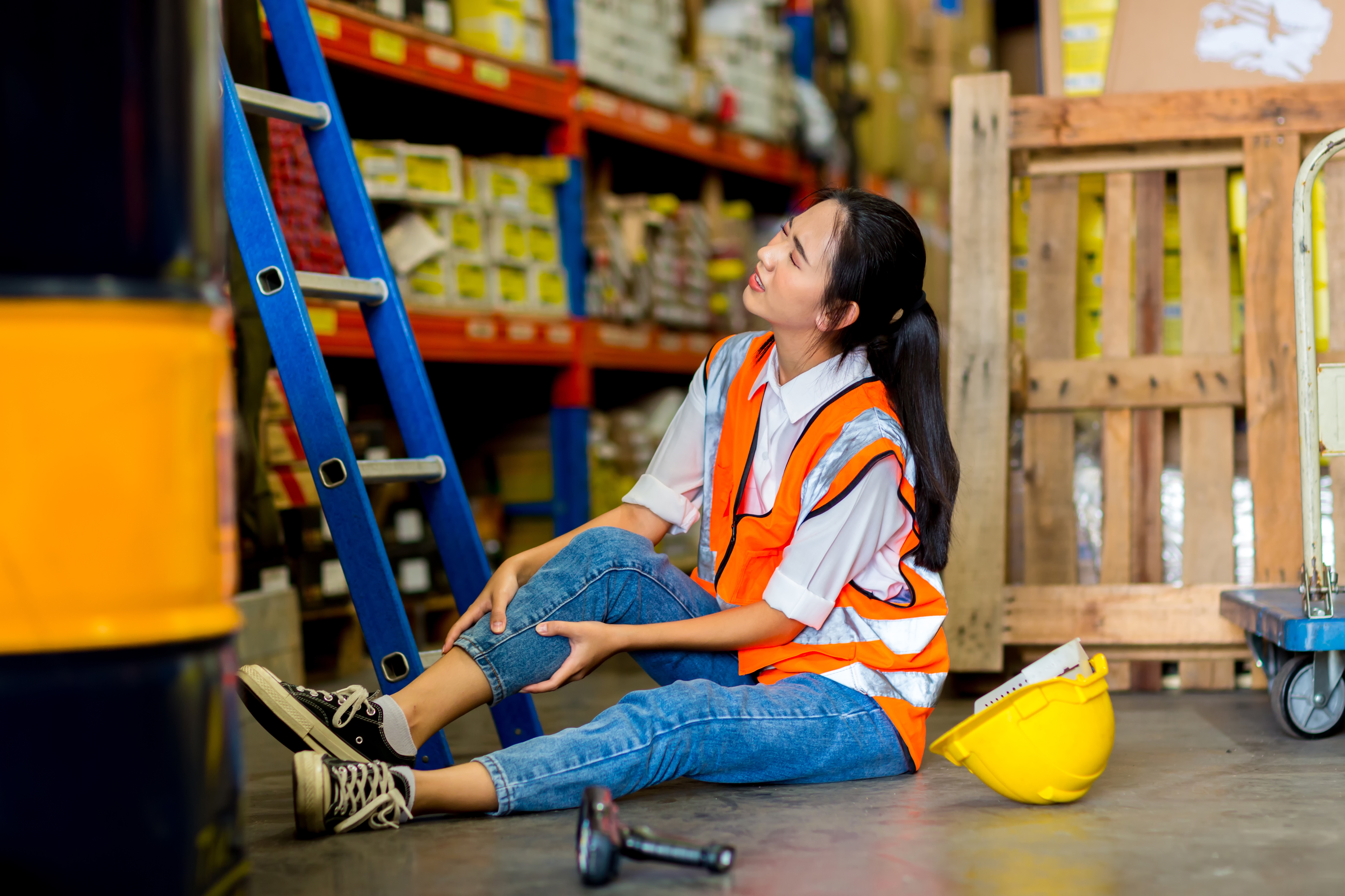 An accident in work site. Woman worker has an accident on the floor in factory site