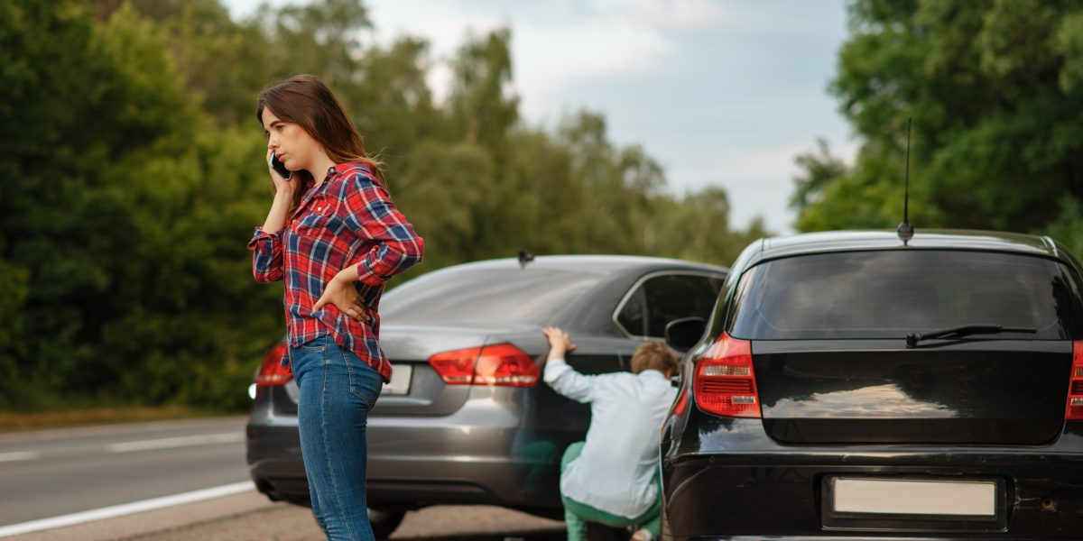 Male and female drivers on road, car accident
